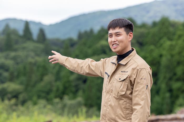 山林を背にするトールさん。日本の木材資源は貴重だと語る
