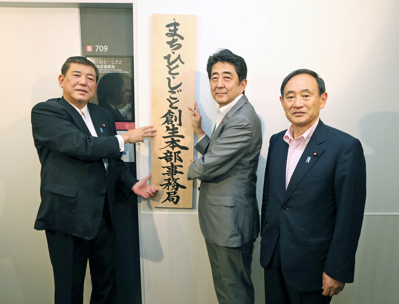 2014年9月、「まち・ひと・しごと創生本部事務局」の看板を掛ける石破地方創生相(左)と安倍首相。右は菅官房長官=東京・永田町